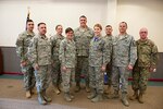 ​U.S. Air Force Capt. Benjamin N. Garland(center), Public Affairs Officer and offensive lineman for the Atlanta Falcons, assigned to the 140th Wing, receives a token of thanks from the Army National Guard at Buckley Air Force Base Feb. 21, 2016. A ceremony was held to honor the collaborative effort put forth by Garland and the Army National Guardsmen to ensure service members understand the importance of head injuries as they relate to the military and the National Football League. (U.S. Air National Guard photo by Senior Airman Bobbie Reynolds)