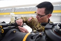 ​U.S. Army Sgt. Benjamin Stocker, Colorado National Guard CH-47 flight engineer and mechanic, puts a washer into place Feb. 19, 2016, at the Army Aviation Support Facility on Buckley Air Force Base, Colo. As a part of installing a new droop-stop spring, the washer keeps the helicopter blades from falling too low during flights. (U.S. Air Force photo by Airman 1st Class Gabrielle Spradling/Released)