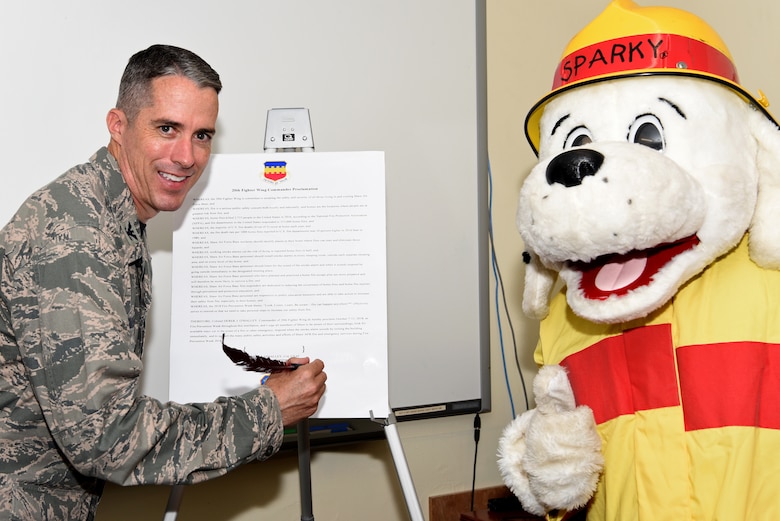 U.S. Air Force Col. Derek O’Malley, 20th Fighter Wing (FW) commander, and Sparky, the fire prevention dog, help promote Fire Prevention Week, at Shaw Air Force Base, S.C., Sept. 17, 2018.