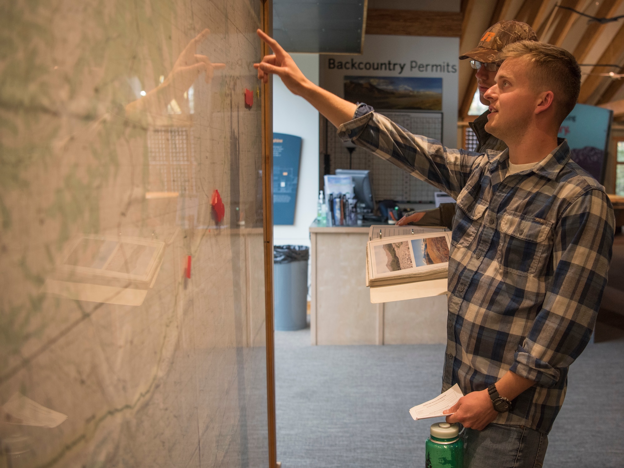 U.S. Air Force 1st Lt. John Ininns, a 673d Medical Group perianesthesia nurse and 1st Lt. Jacob Bowman, a Nellis Air Force Base, Nevada, 99th Medical Group clinical nurse, use a map, hanging in the Main Visitor Center, to plan a trip at Denali National Park and Preserve, Alaska, Sept. 15, 2018. The 11th annual Military Appreciation Day included 400 “road lottery” tickets given out to Alaska-based service members. They used the park’s available resources to plan a backcountry backpacking trip at the park following the event.