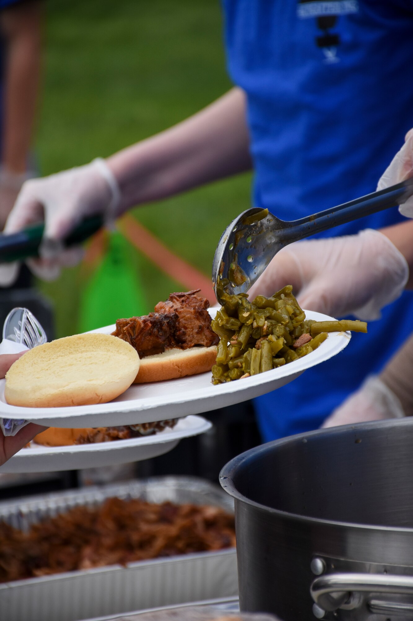 Junior ROTC cadets serve barbecue beef and pork with green beans during the 442d Fighter Wing Family Day event Sept. 9, 2018, at Ike Skelton Park on Whiteman Air Force Base, Mo.