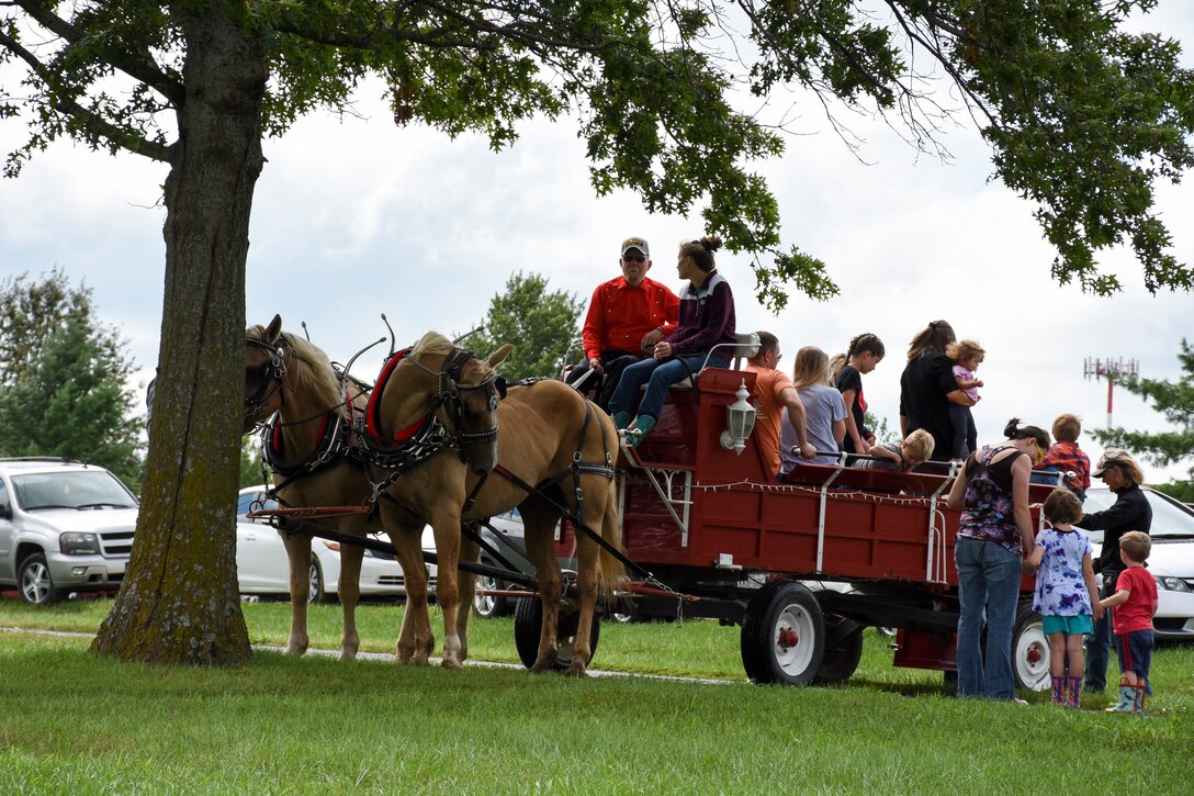 442d Fighter Wing members and their families disembark from a horse-drawn carriage at the 442 FW Family Day event Sept. 9, 2018, at Ike Skelton park on Whiteman Air Force Base, Mo.
