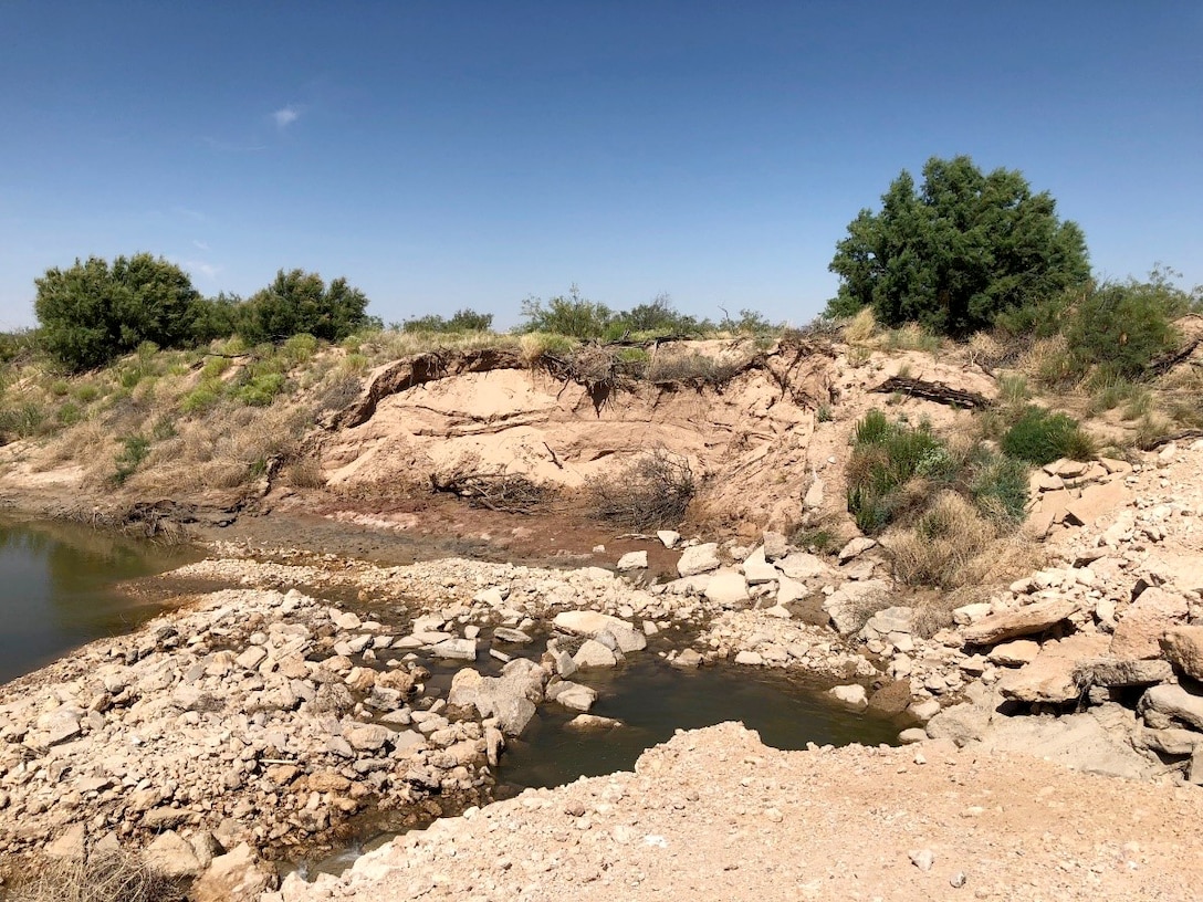 The unauthorized dam failed and caused significant erosion on the west side of the river.