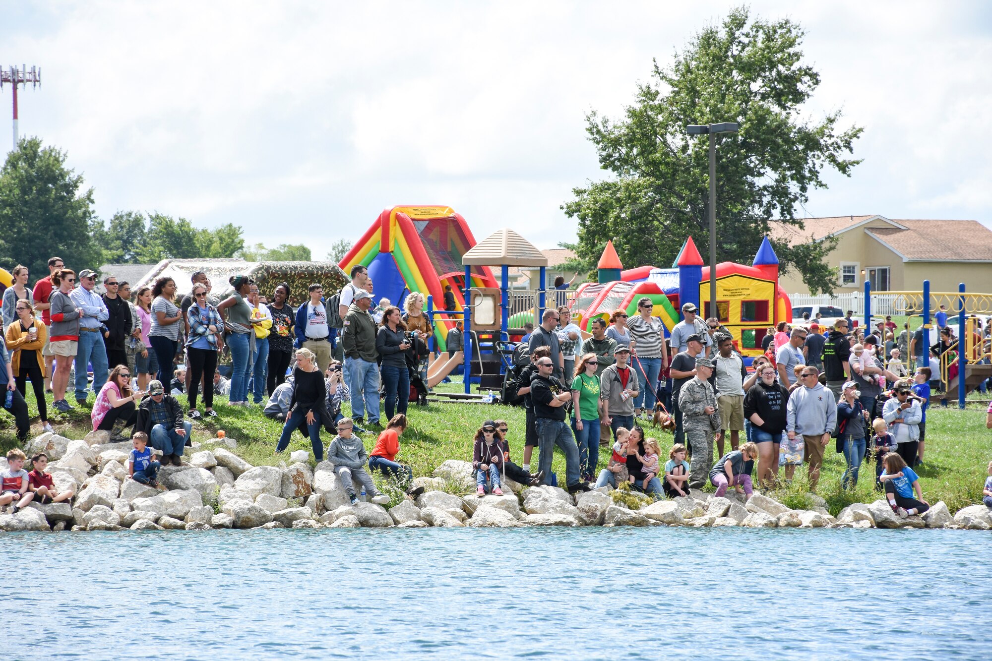 A crowd watches the carboard boats get lowered into the water for the 442d Fighter Wing Family Day Cardboard Regatta Sept. 9, 2018, at Ike Skelton Park on Whiteman Air Force Base, Mo.