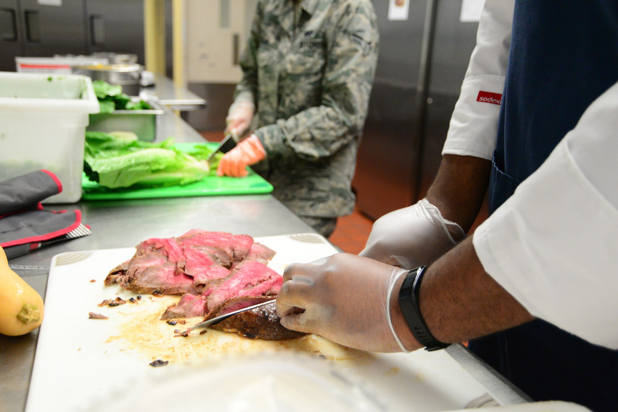 Hassan Amenu-el (front), line cook, and Airman 1st Class Katie Magar, 436th Force Support Squadron food service apprentice, work in tandem to prepare lunch Sept. 14, 2018, at the Patterson Dining Facility on Dover Air Force Base, Del. The combined efforts of Airmen and civilians improve the dining experience for their customers. (U.S. Air Force photo by Airman 1st Class Dedan Dials)