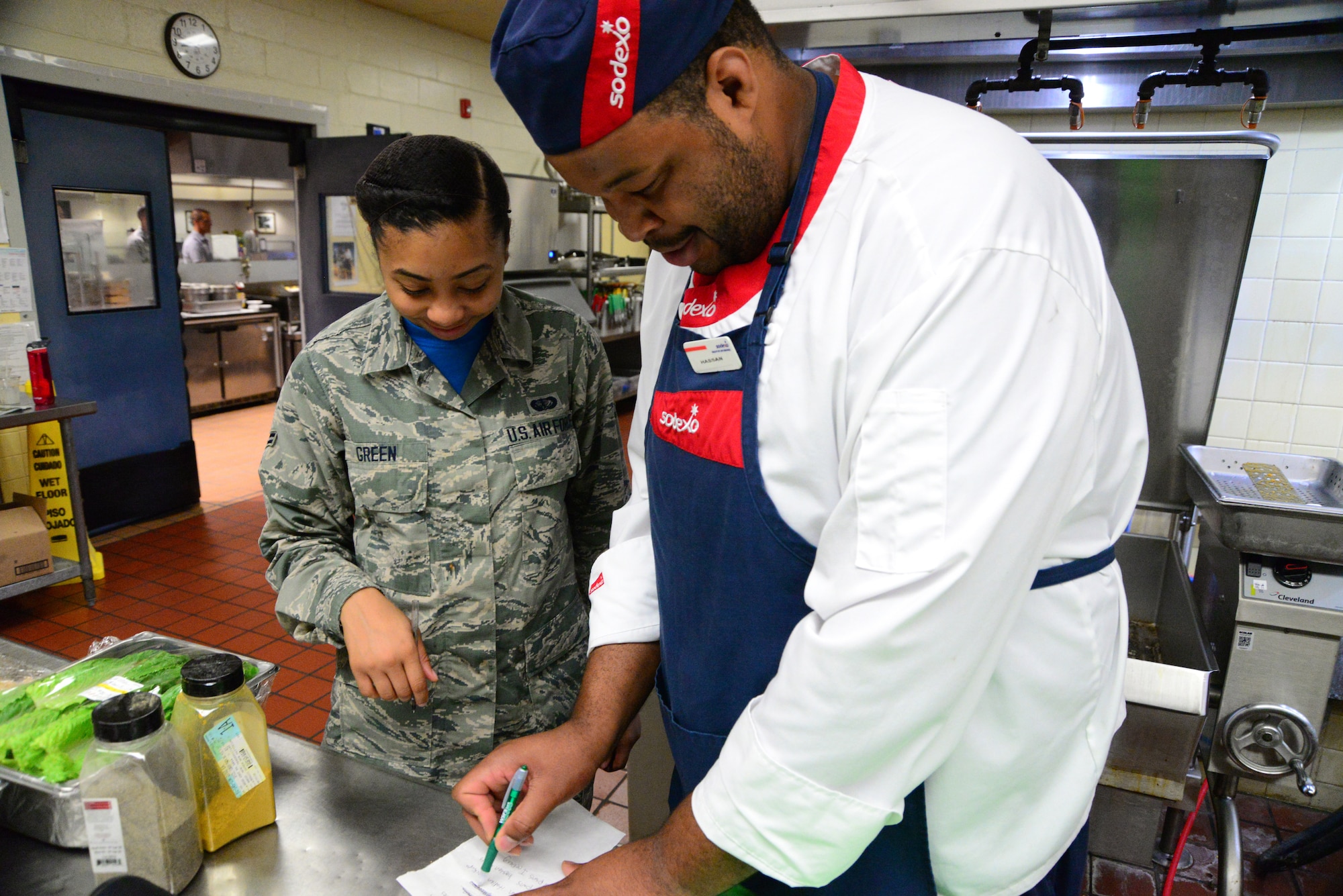 Airman 1st Class Iyana Green (left), 436th Force Support Squadron food service apprentice, and Hassan Amenu-el, line cook, ensure they meet their objectives for the morning preparation Sept. 14, 2018, at the Patterson Dining Facility on Dover Air Force Base, Del. The civilians and Airmen have a policy of transparency and communication to improve team efficiency and cohesion. (U.S. Air Force photo by Airman 1st Class Dedan Dials)