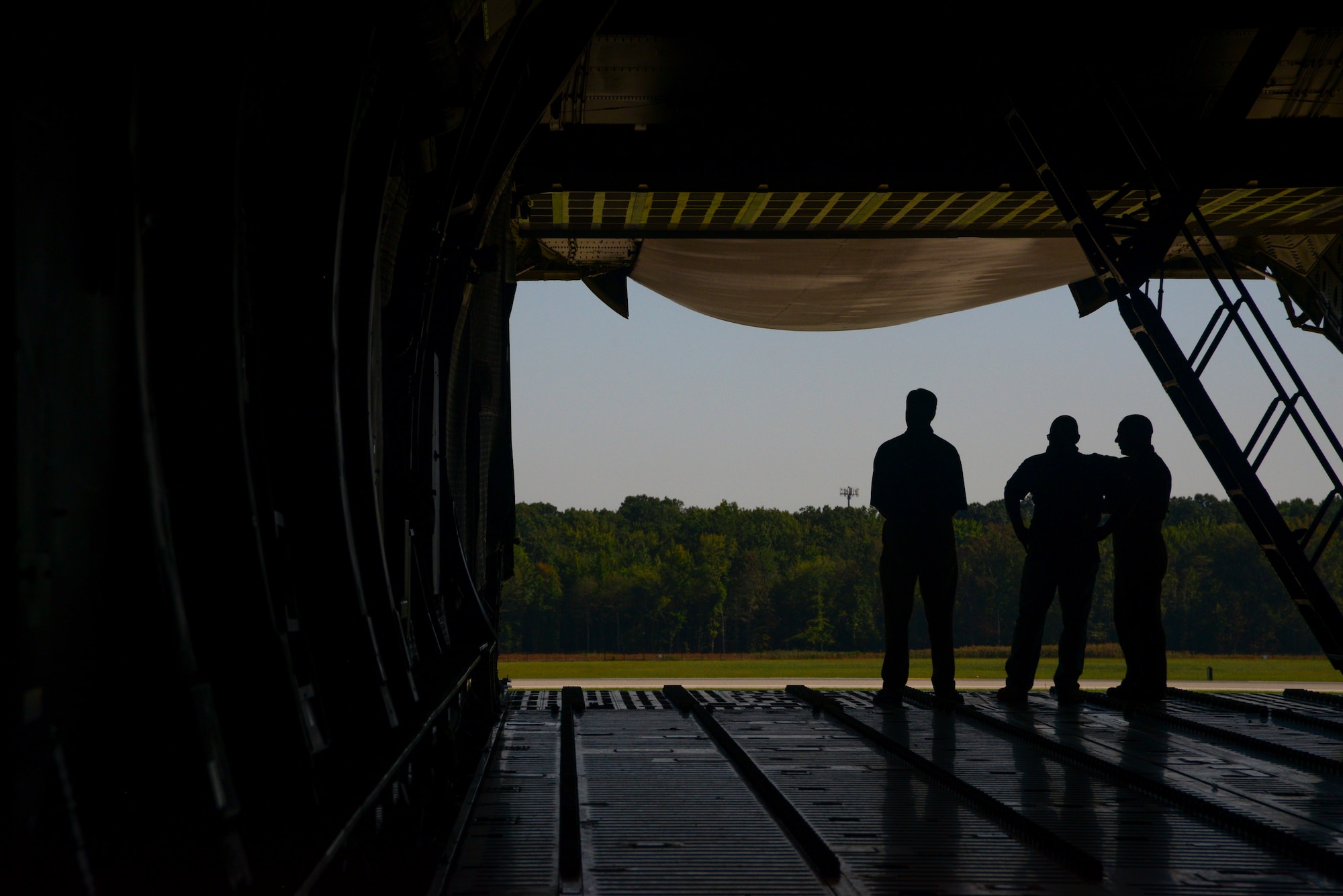 Members look out the tail end of a C-5M Super Galaxy assigned to the 3rd Airlift Squadron Sept. 5, 2018. Marine Corps Systems Command land systems defense acquisition engineers and logisiticans visited Dover AFB to develop ideas on how to better assist with loadmaster capabilities. (U.S. Air Force photo by Airman 1st Class Jonathan Harding)