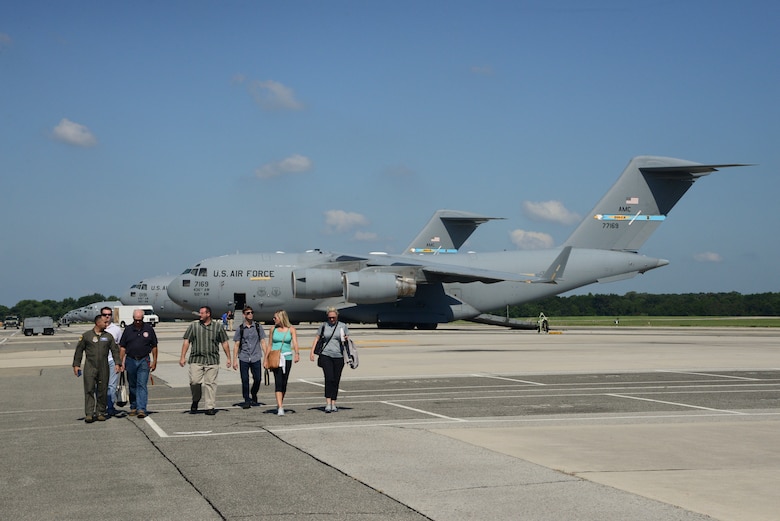 A group of land systems defence acquisition engineers and logisiticans from the Marine Corps Systems Command walks on the flight line after a tour on a C-17 Globemaster III Sept. 5, 2018 Sept. 5, 2018 at Dover Air Force Base, Del. Their visit was intended to imrpove the partnership between loadmasters and MARCORSYSCOM. (U.S. Air Force photo by Airman First Class Jonathan Harding.)