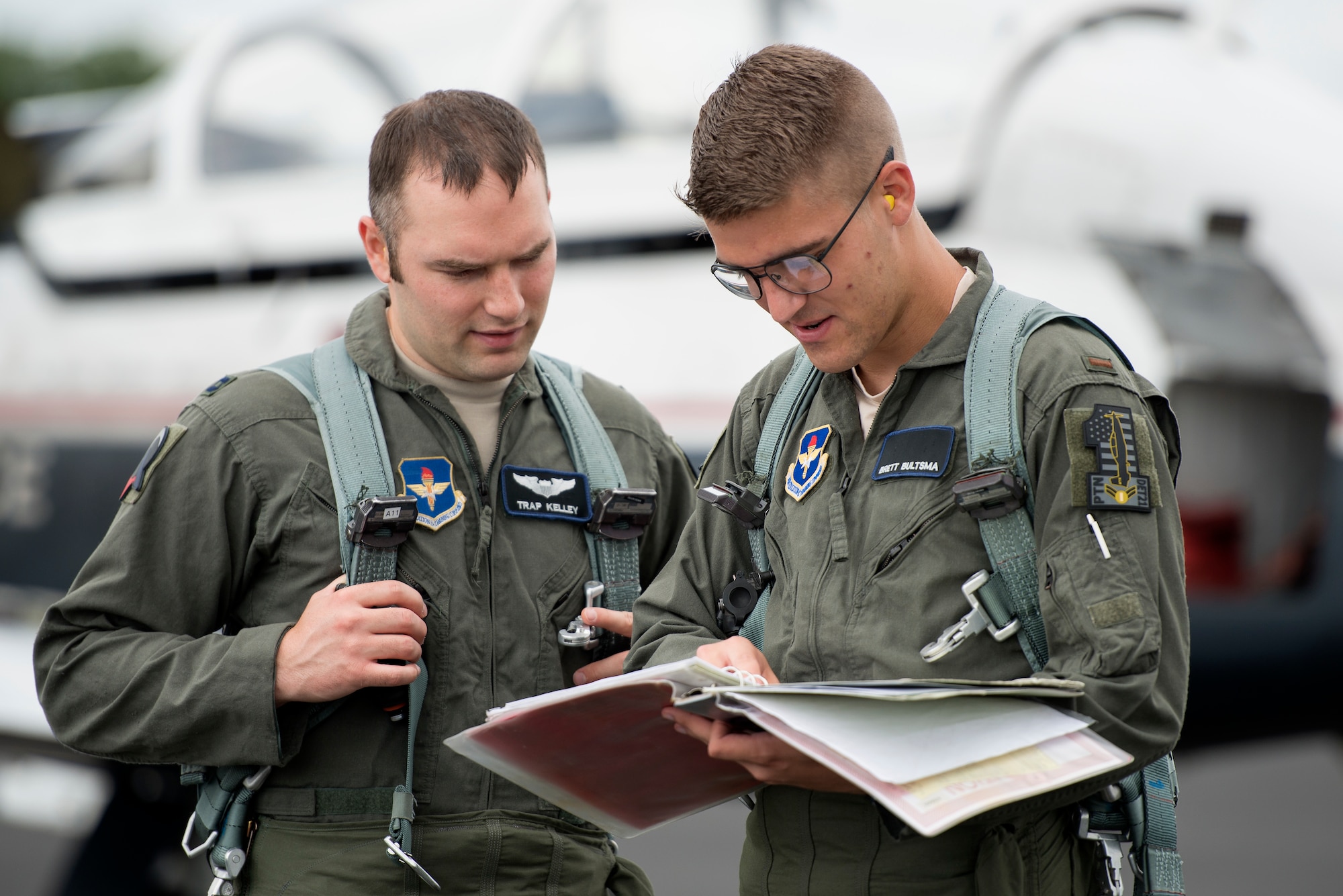 U.S. Air Force Capt. Jeffery Kelley, Pilot Training Next instructor pilot, and 2nd Lt. Brett Bultsma, PTN student, look over the flight plans for their training mission at Austin-Bergstrom International Airport in Austin, Texas June 18, 2018. PTN is an Air Education and Training Command initiative to explore and potentially prototype a training environment that integrates various technologies to produce pilots in an accelerated, cost-efficient, learning-focused manner. Air Education and Training Command officials announced the second iteration of Pilot Training Next would begin in January 2019 during a panel at the 2018 Air Force Association Air, Space and Cyber Conference in National Harbor, Maryland. (U.S. Air Force photo by Sean M. Worrell)