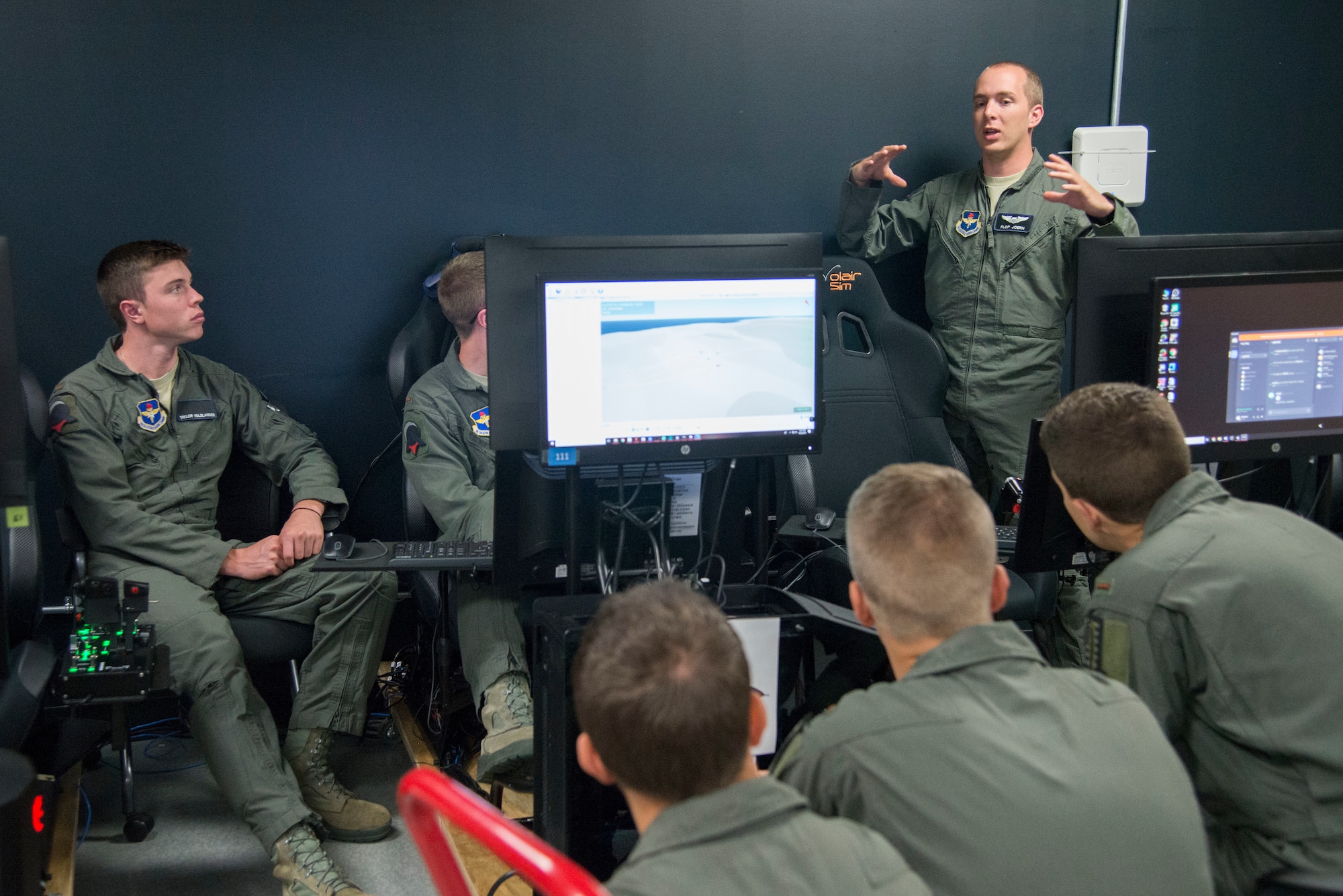 U.S. Air Force Capt. Johnathan Joern (standing), Pilot Training Next instructor pilot, trains PTN students on flying procedures at the Armed Forces Reserve Center in Austin, Texas, June 22, 2018. Air Education and Training Command officials announced the second iteration of Pilot Training Next would begin in January 2019 during a panel at the 2018 Air Force Association Air, Space and Cyber Conference in National Harbor, Maryland. (U.S. Air Force photo by Sean M. Worrell)