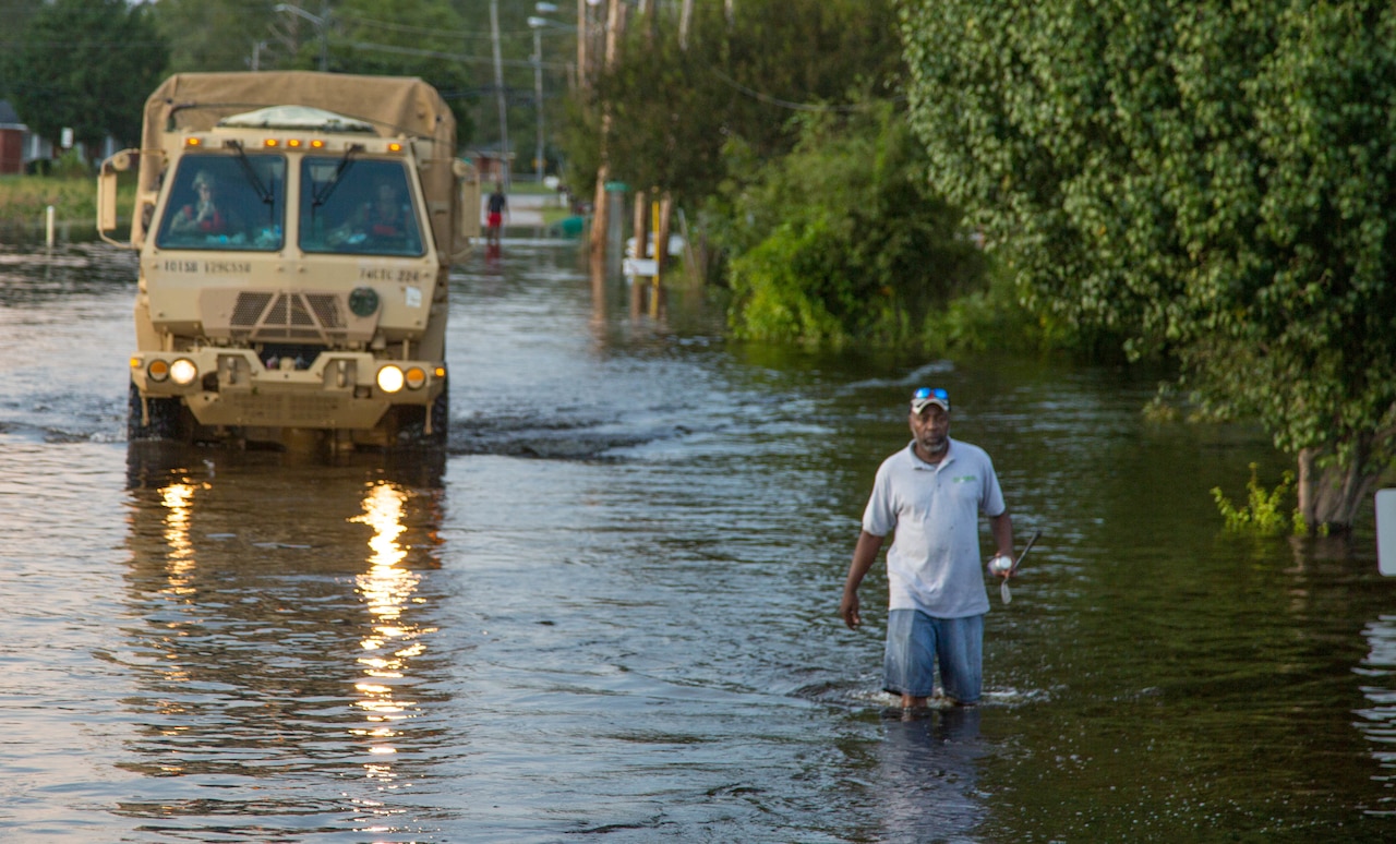 Soldiers arrive at flood scene in high-water vehicle.