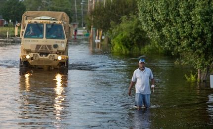 Soldiers arrive at flood scene in high-water vehicle.