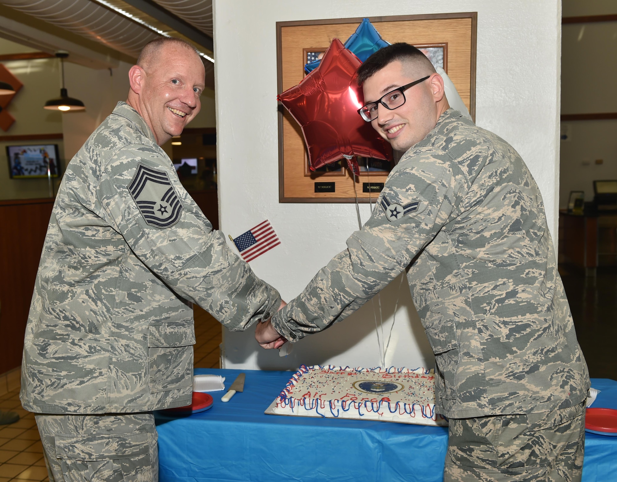 U.S. Air Force Chief Master Sgt. Paul Pohnert, the group superintendent of the 97th Mission Support Group and Airman 1st Class Tanner Rakoz, a food service specialist assigned to the 97th Force Support Squadron, cut a cake celebrating the U.S. Air Force’s 71st birthday, Sept. 18, 2018, at Altus Air Force Base, Okla. It is tradition to have the oldest and youngest Airmen cut the cake on the service’s birthday.