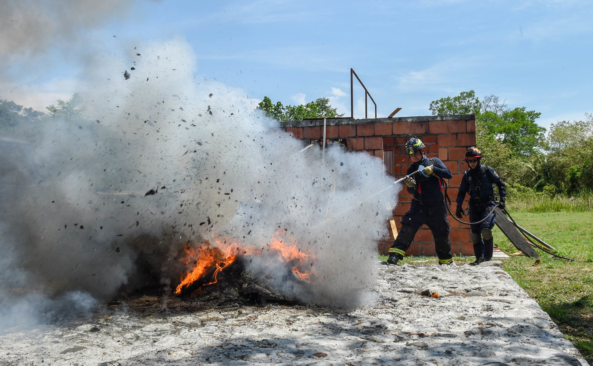 Colombian firefighters put out a fire during a mass casualty earthquake simulation as part of the multilateral exercise Angel de los Andes Sept. 6, 2018, at German Olano Air Base, Colombia. The first week of the exercise is focused on responding to natural disaster scenarios that include an earthquake response, a forest fire and an open water rescue, as well as responding to an aircraft crash.  (U.S. Air Force photo by Staff Sgt. Robert Hicks)