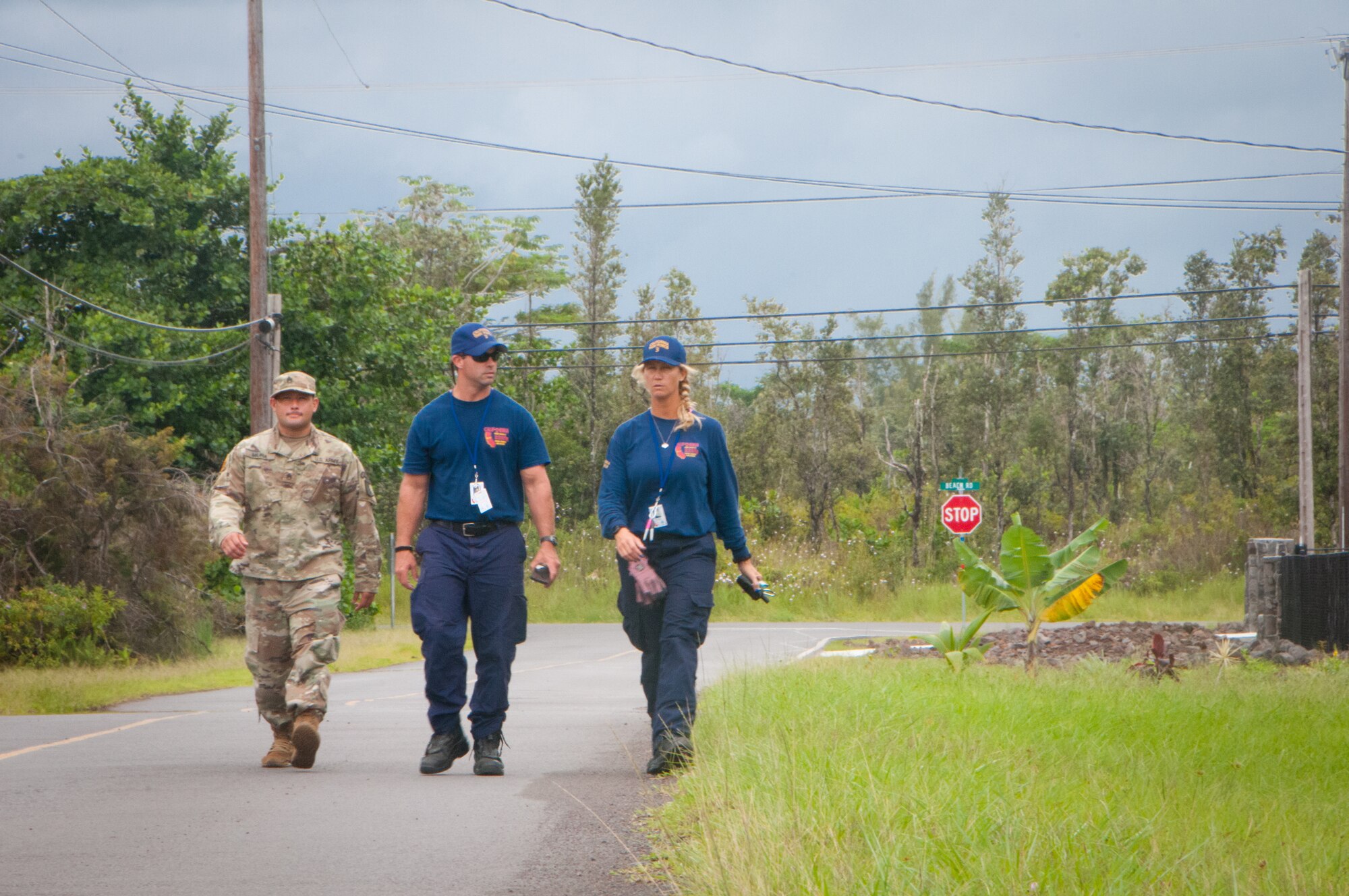 Staff Sgt. William Muira, from the Hawaii National Guard's CBRNE Enhanced Response Force Package (CERFP) Team, escorts FEMA Urban Search and Rescue members from California Task Force 3 while they perform a wide area assessment in the wake of Hurricane Lane