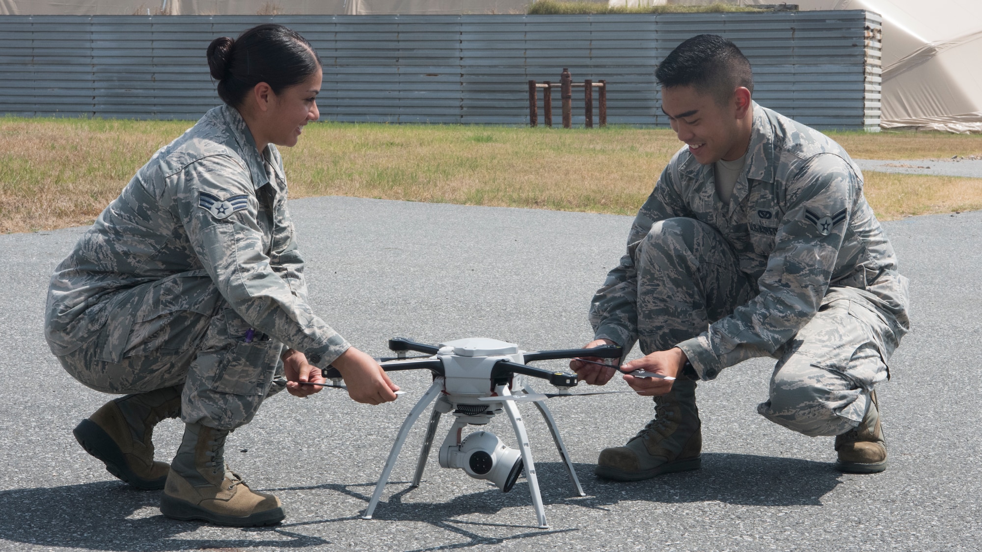 U.S. Air Force Senior Airman Rebecca Garcia (left), and Airman 1st Class Alexander Avenido (right), 8th Civil Engineering Squadron assistant engineering technicians, inspect an Aeryon SkyRanger drone prior to the Air Force’s first-ever operational rapid airfield damage assessment at Kunsan Air Base, Republic of Korea, Aug. 13, 2018. This innovative survey method gives both the engineers and base leadership the capability to have a clear over-head view, rewind and zoom in or out to view the airfield during assessments. (U.S. Air Force photo by Staff Sgt. Levi Rowse)