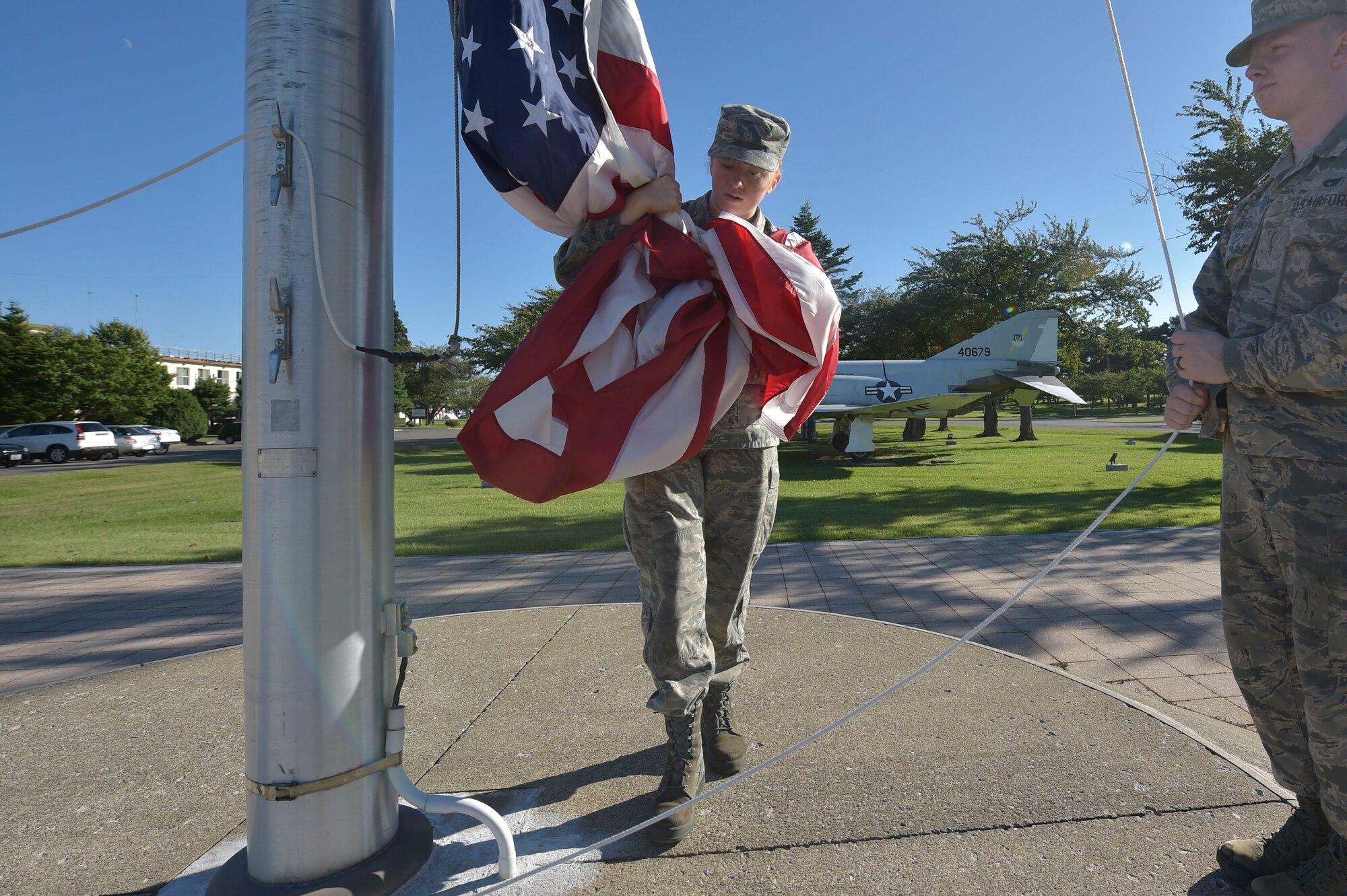 U.S. Air Force Senior Airman Sarah Rose, left, and Airman 1st Class William Gage, right, both 35th Honor Guard guardsman practice retreat ceremony flag folding at Misawa Air Base, Japan, Sept. 17, 2018. Misawa guardsmen show respect to former military members by performing flag folding and presenting the colors at ceremonies, funerals and other special events across the base and around the local area.  (U.S. Air Force photo by Tech. Sgt. Stephany Johnson)