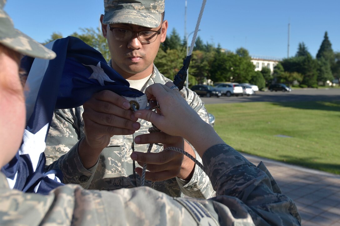 U.S. Air Force Senior Airman Sarah Rose, left, and Senior Airman Francisco Valdepenas, right, both 35th Honor Guard guardsman practice retreat ceremony flag folding at Misawa Air Base, Japan, Sept. 17, 2018. The training period to be a guardsman is self-paced and usually takes two months to complete. (U.S. Air Force photo by Tech. Sgt. Stephany Johnson)