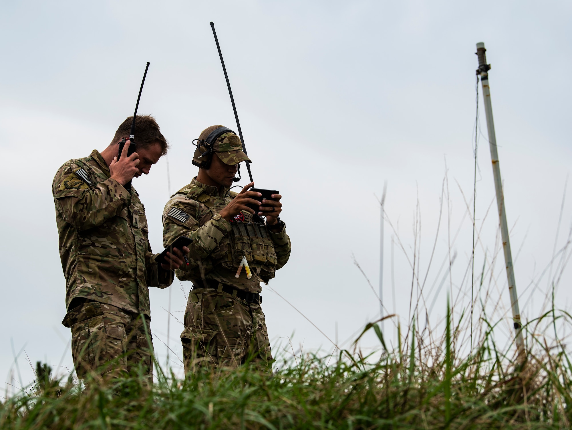 U.S. Air Force 1st Lt. Clay West, air liaison officer from the 15th Air Support Operations Squadron, Fort Stewart, Georgia (left), listens to a soldier from the 7th Special Forces Group communicate with a live aircraft Sept. 13, 2018 at Kunsan Air Base, Republic of Korea. Special Forces soldiers must be well versed in multiple aspects of modern combat, such as being able to call in air strikes when no trained personnel are available. (U.S. Air force photo by Senior Airman Stefan Alvarez)