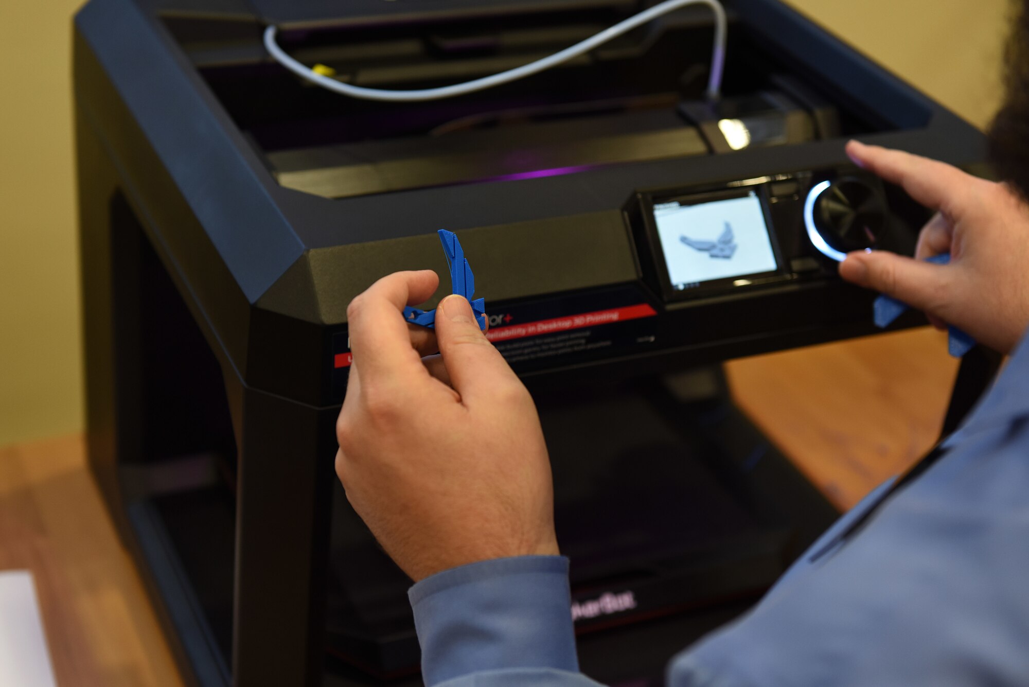 Librarian Thomas Lynch holds a U.S. Air Force symbol that was printed by a MakerBot Replicator 3-D printer at Incirlik Air Base, Turkey, Sept. 18, 2018.