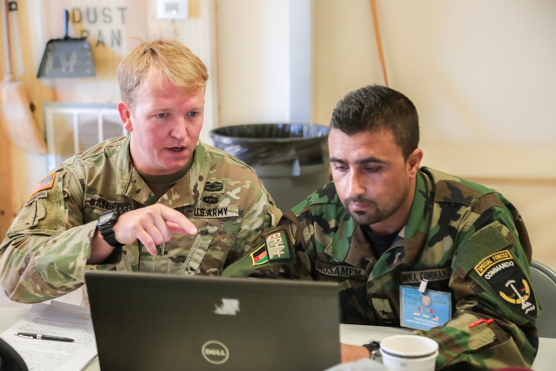 Massachusetts Army National Guard Sgt. 1st Class Joshua Bainbridge (left) and an Afghanistan Special Forces commando react to a simulated event during command post exercise Regional Cooperation 18 at Camp Edwards on Joint Base Cape Cod, Massachusetts, Sept. 15, 2018. Regional Cooperation is an annual exercise conducted by multiple national partners focusing on stability operations, border security and control, counter terrorism, counter narcotics, and counter proliferation. (U.S. Central Command Public Affairs photo by Tom Gagnier)