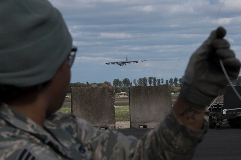 U.S. Air Force Staff Sgt. Jasmine Williams, a munitions systems technicians assigned to the 343rd Expeditionary Bomb Squadron, catches a glimpse of a B-52 Stratofortress landing at RAF Fairford, England, Sept. 7, 2018.   She was on hand as part of Ample Strike 18 and the Bomber Task Force operating out of the base. (U.S. Air Force photo by Master Sgt. Ted Daigle)