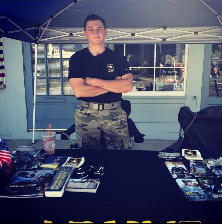 A soldier poses in a recruiting booth.