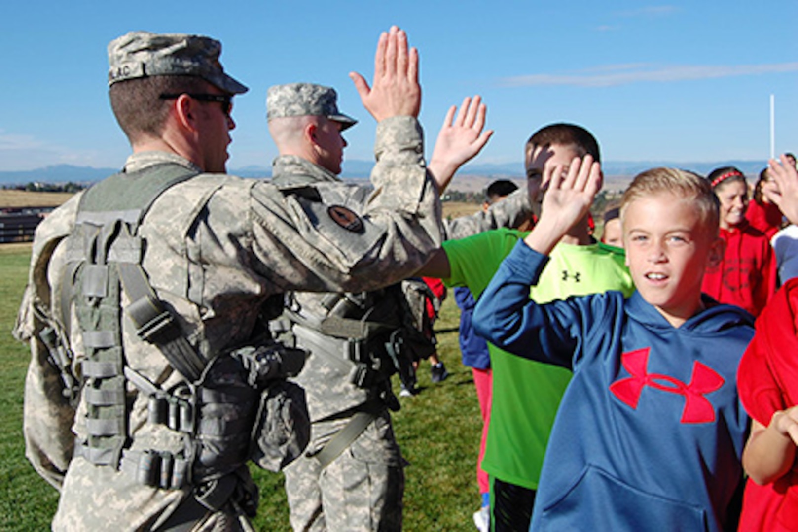 Chief Warrant Officer 2 Marc Kudlac, UH-60 pilot, and Sgt. Sam Groff, UH-60 crew chief, Colorado Army National Guard, high-five students at Cimarron Middle School during a Red Ribbon Week school visit. The Colorado National Guard's Joint Counterdrug Task Force conducts almost a hundred visits like this over the course of each year in an effort to inspire kids in Colorado to stay drug-free.