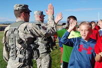 Chief Warrant Officer 2 Marc Kudlac, UH-60 pilot, and Sgt. Sam Groff, UH-60 crew chief, Colorado Army National Guard, high-five students at Cimarron Middle School during a Red Ribbon Week school visit. The Colorado National Guard's Joint Counterdrug Task Force conducts almost a hundred visits like this over the course of each year in an effort to inspire kids in Colorado to stay drug-free.