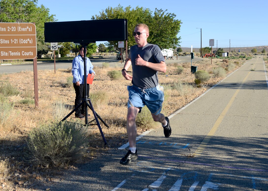 Capt. Brian Peterson, 452nd Flight Test Squadron, crosses the finish line during the Air Force Birthday 5k Run at Edwards Air Force Base, California, Sept. 18, 2018. Peterson finished the race in first place, over all. (U.S. Air Force photo by Giancarlo Casem)