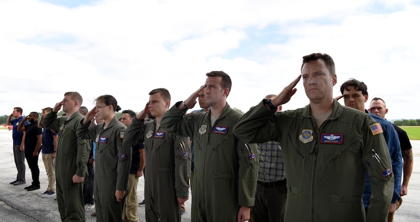 The aircrew salute the remains of WWII heroes as they pass during a flight line ceremony Sept. 14, 2018, at Offutt Air Force Base, Nebraska. Aircrew from Joint Base Charleston, S.C. was tasked to deliver the remains due to its rapid mobility capabilities.
