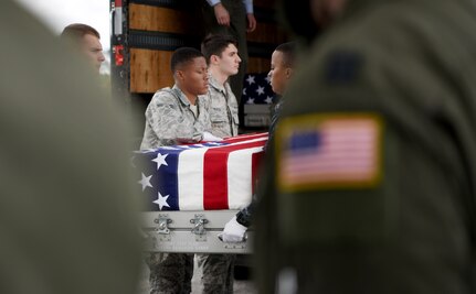 Members of the honor guard carry a transfer case off of a C-17 Globemaster III during a repatriation ceremony of 26 WWII human remains Sept. 14, 2018, at Offutt Air Force Base, Nebraska. Aircrew from Joint Base Charleston, S.C. was tasked to deliver the remains due to its rapid mobility capabilities.