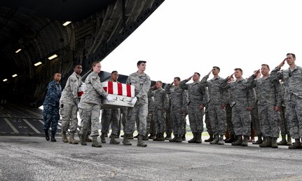 Attendees of a repatriation ceremony salute 26 WWII human remains as they are unloaded Sept. 14, 2018, at Offutt Air Force Base, Nebraska. Aircrew from Joint Base Charleston, S.C. was tasked to deliver the remains due to its rapid mobility capabilities.