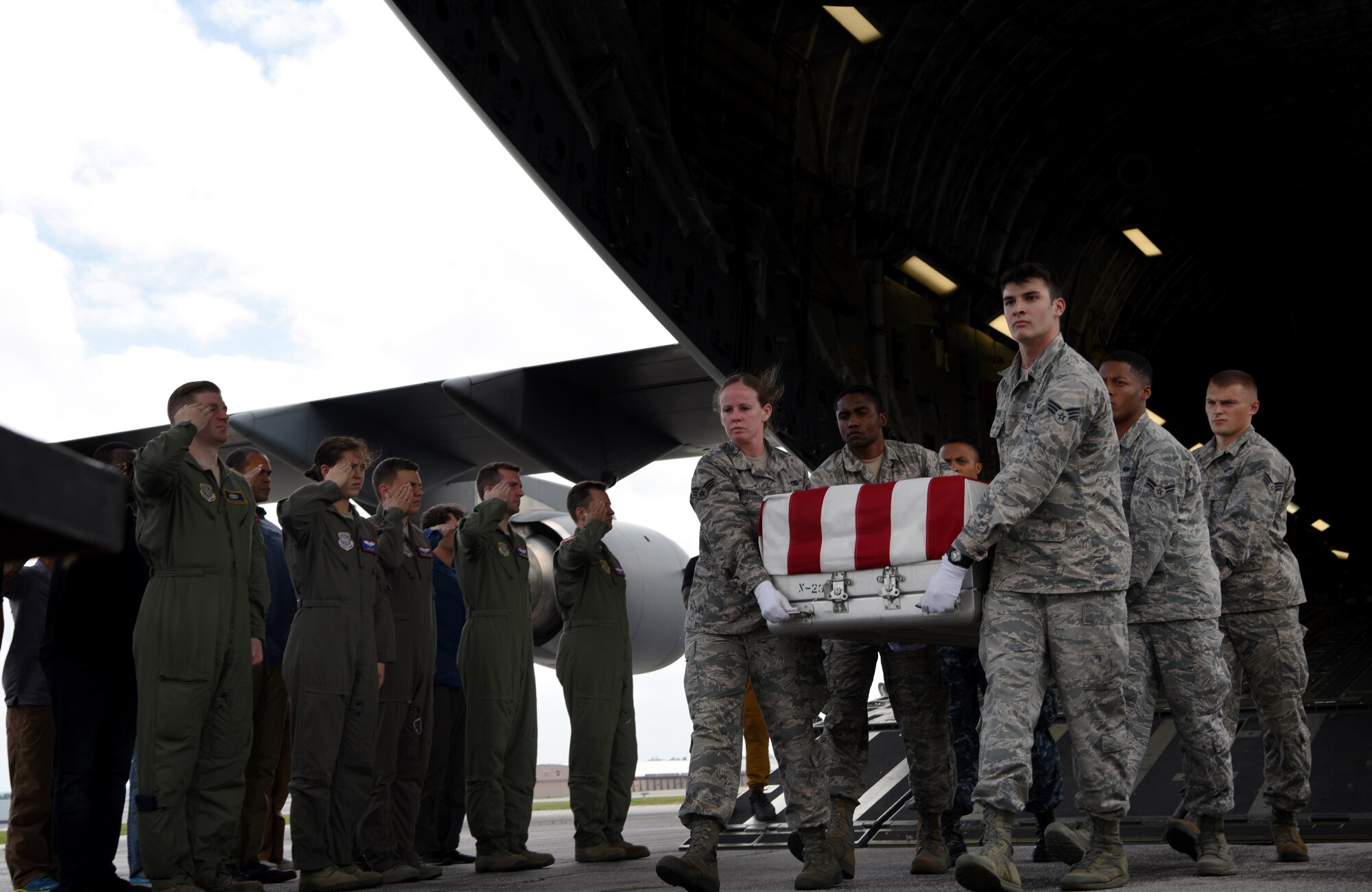 The aircrew salute the remains of WWII heroes as they pass during a repatriation ceremony Sept. 14, 2018, at Offutt Air Force Base, Nebraska. Aircrew from Joint Base Charleston, S.C. was tasked to deliver the remains due to its rapid mobility capabilities