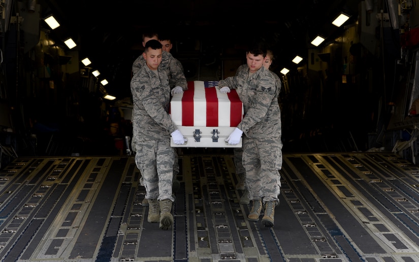 Members of the honor guard carry a transfer case off of a C-17 Globemaster III during a repatriation ceremony of 26 WWII human remains Sept. 14, 2018, at Offutt Air Force Base, Nebraska. Aircrew from Joint Base Charleston, S.C. was tasked to deliver the remains due to its rapid mobility capabilites