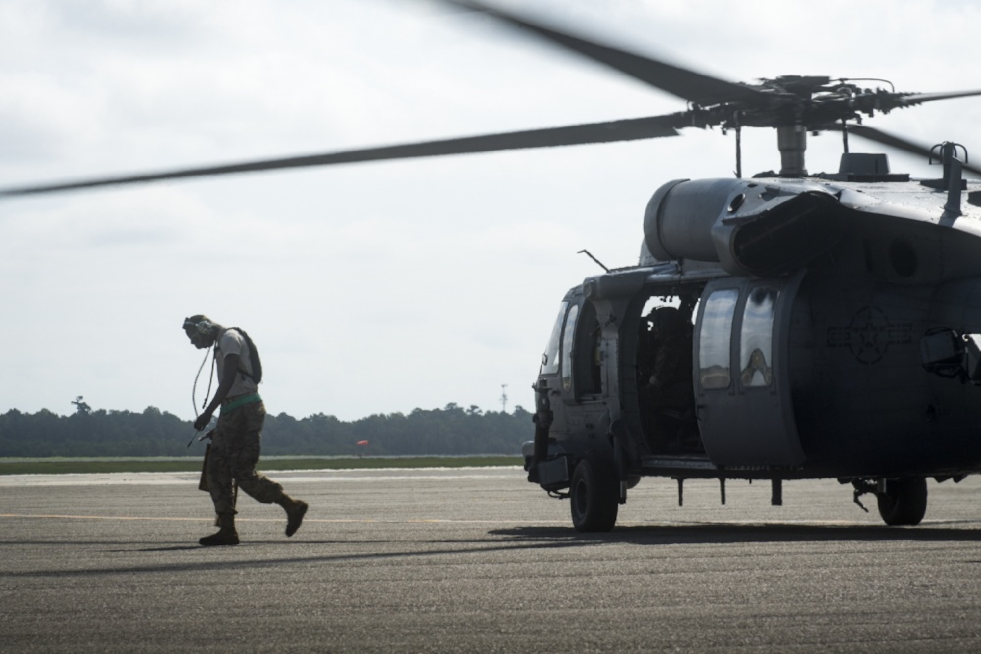 Senior Airman Marlon Natty, 334th Air Expeditionary Group crew chief, pulls the chocks from under an HH-60G Pave Hawk as it prepares for an area familiarization flight, Sept. 17, 2018, at Joint Base Charleston, S.C. The 334th AEG is an expeditionary search and rescue unit, which is pre-positioned to provide relief in the wake of tropical storm Florence. Comprised of 23d Wing and 920th Rescue Wing personnel and assets, the 334th AEG is ready to perform surface, fixed wing and rotary SAR operations if called upon.