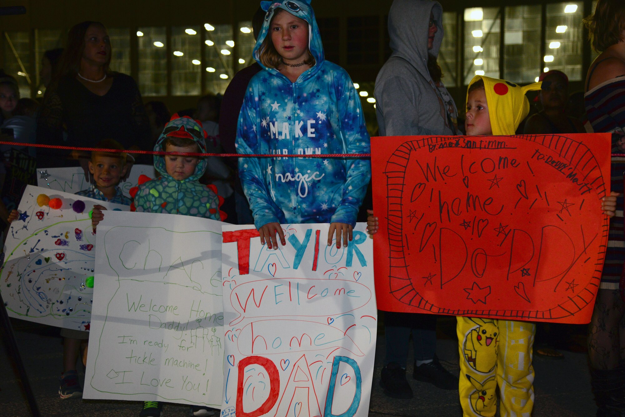 The family of Master Sgt. Matthew Timm, the 28th Aircraft Maintenance Squadron noncommissioned officer in charge of loading, holds up signs as they await his return from a six-month deployment to Al Udeid Air Base, Qatar, Sept. 18, 2018. During the deployment, Ellsworth AFB aircrews provided theater commanders with critical long-range strike capability, persistent presence, large diverse weapons payload and organic sensors. (U.S. Air Force photo by Senior Airman Denise M. Jenson)