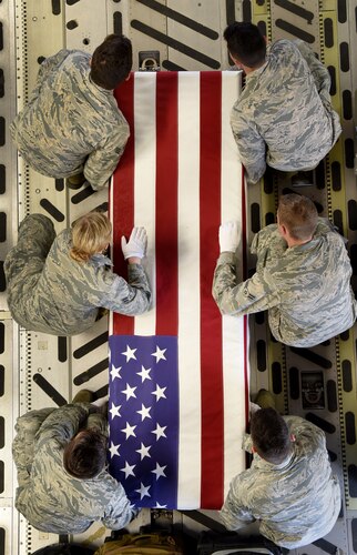 Airmen carry a transfer case off of a C-17 Globemaster III during a  ceremony of 26 WWII human remains Sept. 14, 2018, at Offutt Air Force Base, Nebraska. Aircrew from Joint Base Charleston, S.C. was tasked to deliver the remains due to its rapid mobility capabilities.