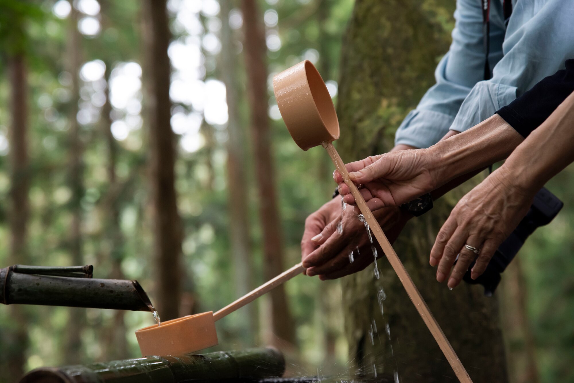 Japanese nationals purify their hands with a hishaku at Chusonji Temple in Hiraizumi, Japan, Sept. 15, 2018. The 35th Fighter Wing's chapel team orchestrated a free resiliency trip to active-duty service members and their families, focusing on appreciating personnel for their hard work, while giving them a chance to recharge by traveling at no cost. A hishaku is a Japanese purification tool used to purify one's hands and body before entering a sacred area. (U.S. Air Force photo by Senior Airman Sadie Colbert)