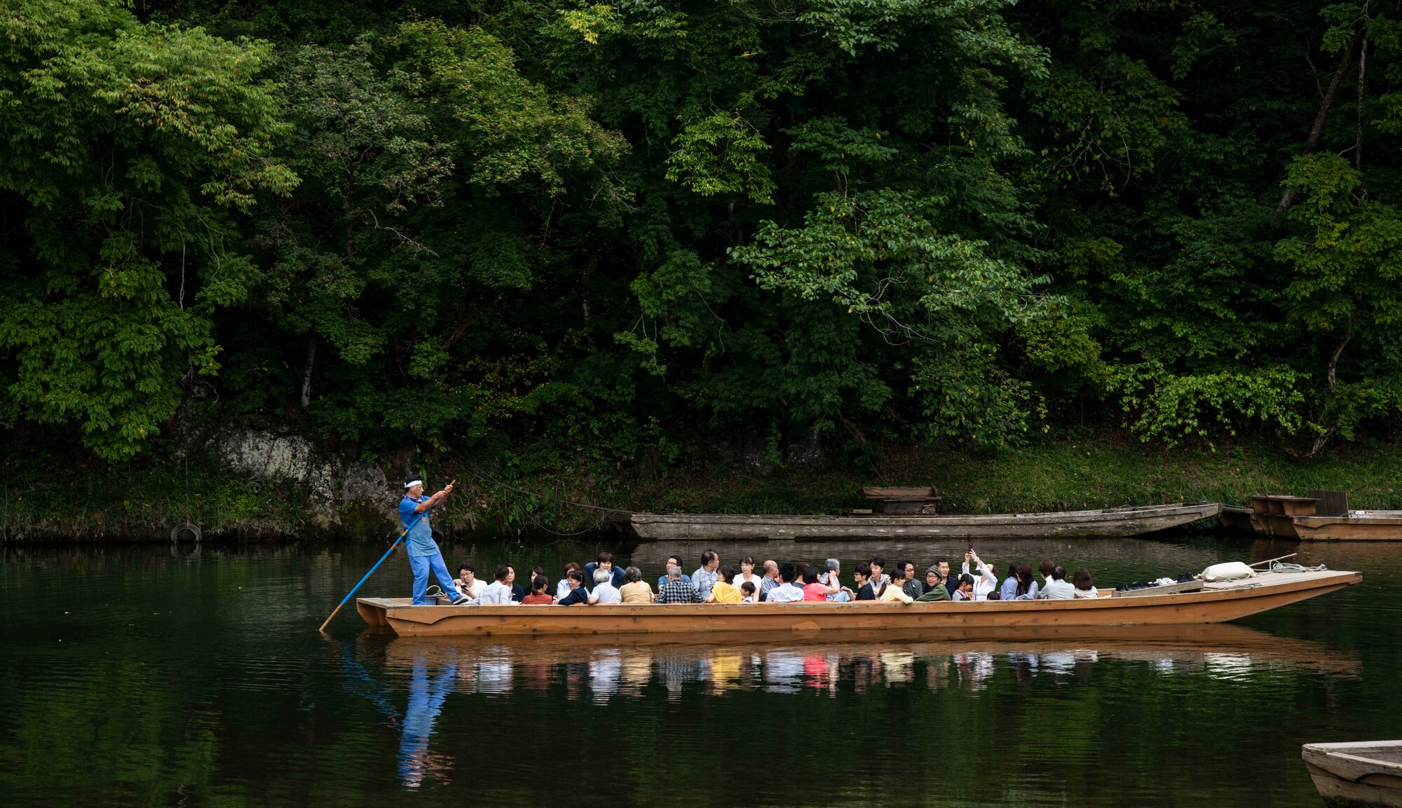 A Japanese boatman pushes visitors on a transportation boat at Geibikei Gorge in Inchinoseki, Japan, Sept. 15, 2018. The boats transport goods across waterways and can hold up to approximately 40 people. The 35th Fighter Wing Chapel initiated trips to local areas in Japan in order to thank service members and their families for their edication to their country. (U.S. Air Force photo by Senior Airman Sadie Colbert)