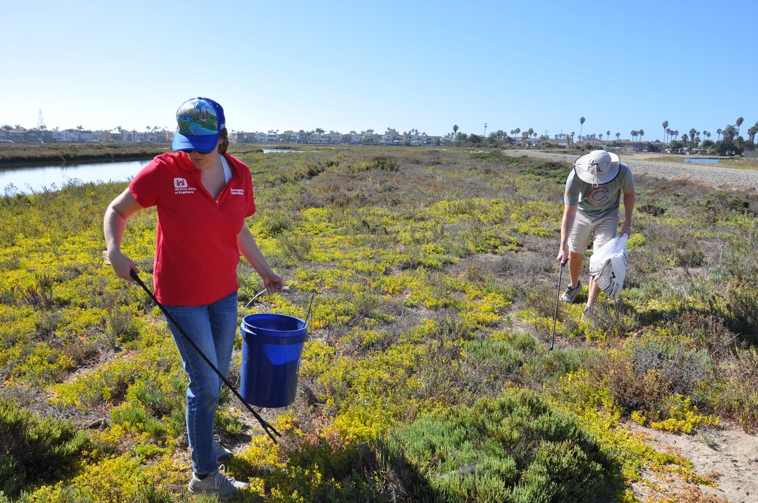 Erin Jones, a biologist with the U.S. Army Corps of Engineers Los Angeles District, left, and her brother, Andrew Hardison, right, pick up trash during the Santa Ana River Marsh Cleanup Day Sept. 15 in Newport Beach, California. The event was part of California Coastal Cleanup Day.
