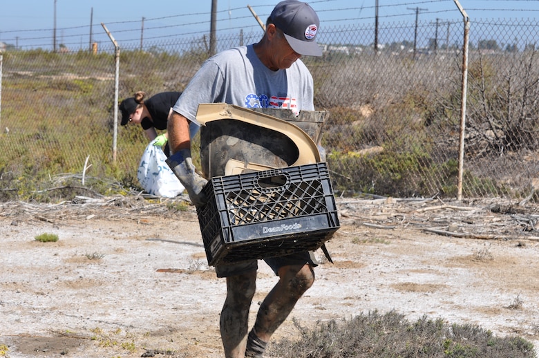 Gary Reynolds of Costa Mesa, California, hauls off a crate of trash during the Santa Ana River Marsh Cleanup Day Sept. 15 in Newport Beach, California. The event was part of California Coastal Cleanup Day.