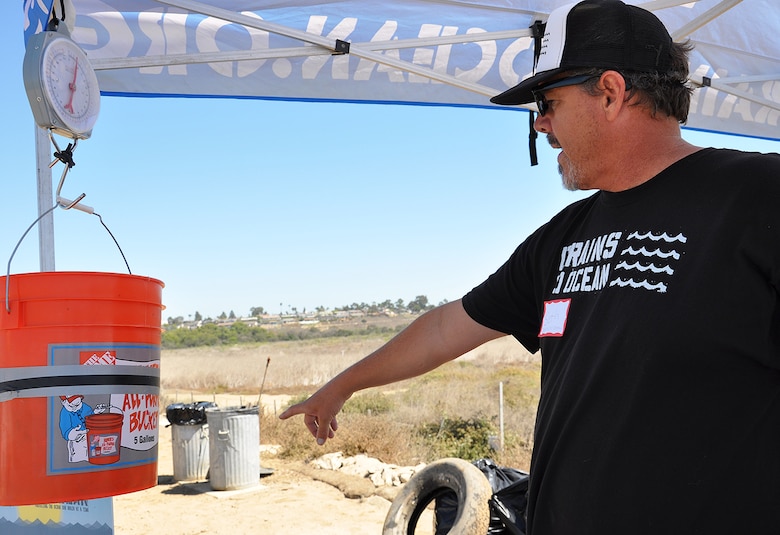 Seth Matson, a volunteer from Drains to Ocean, points to an area to put trash after it is weighed during the Santa Ana River Marsh Cleanup Day Sept. 15 in Newport Beach, California. The event was part of California Coastal Cleanup Day.