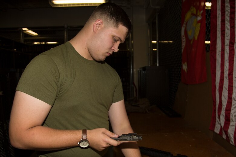 Lance Cpl. Joey Rhodes inspects a bolt carrier group from a M16 A4 service rifle Aug. 9, 2018 at the Camp Foster armory, Okinawa, Japan.