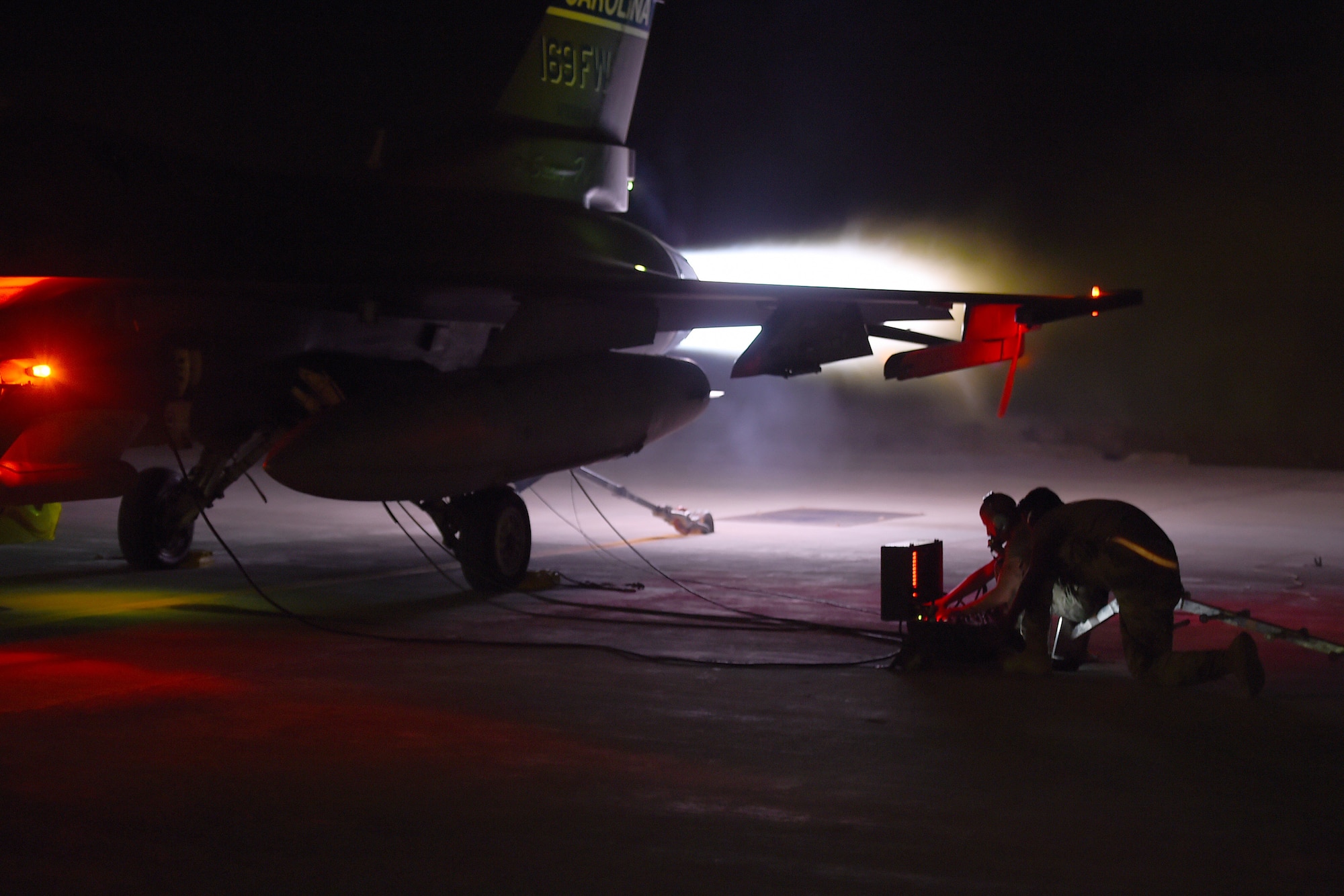 An  F-16 Fighting Falcon performs and afterburner run on the flightline at night