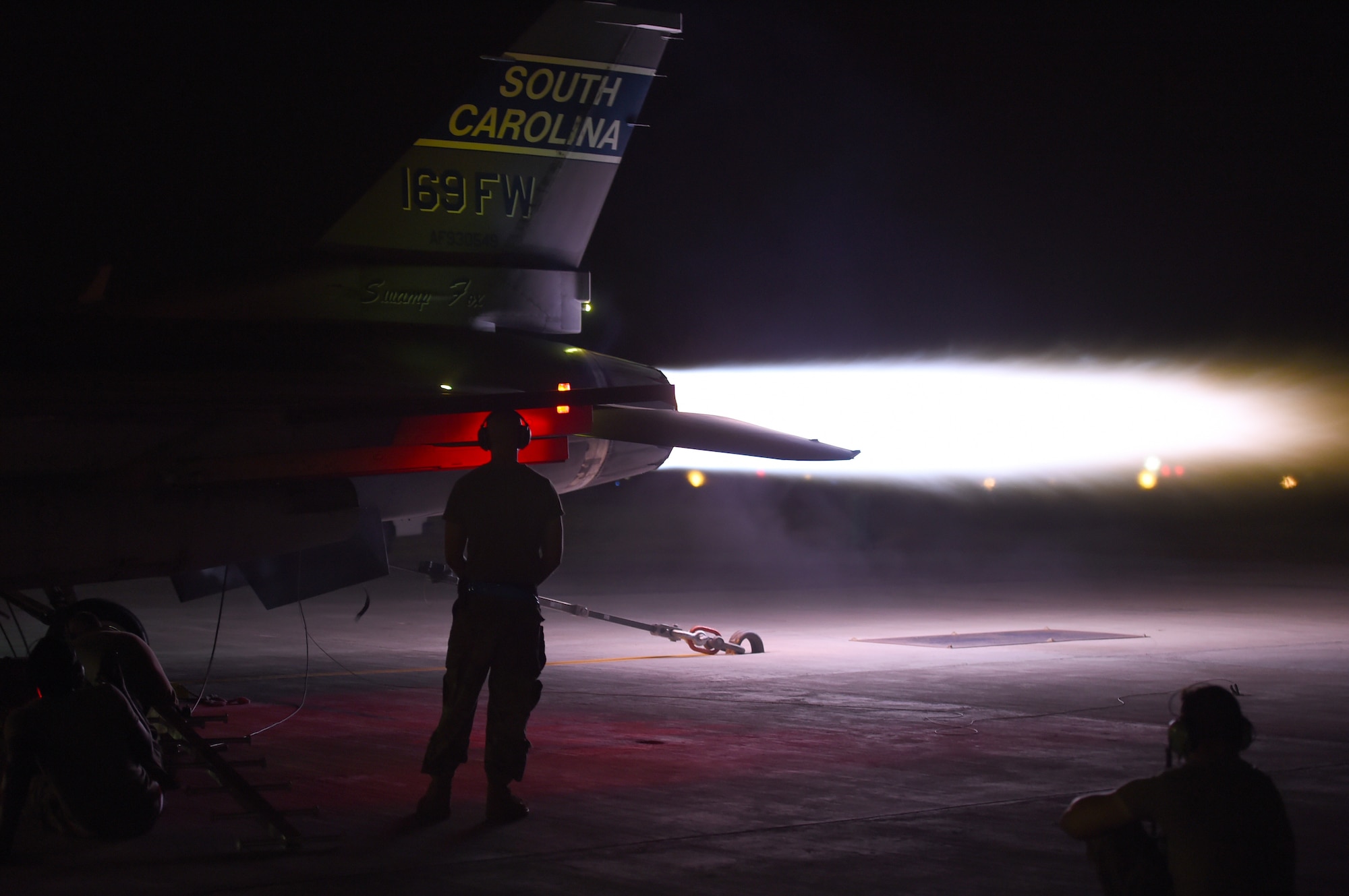 An  F-16 Fighting Falcon performs and afterburner run on the flightline at night