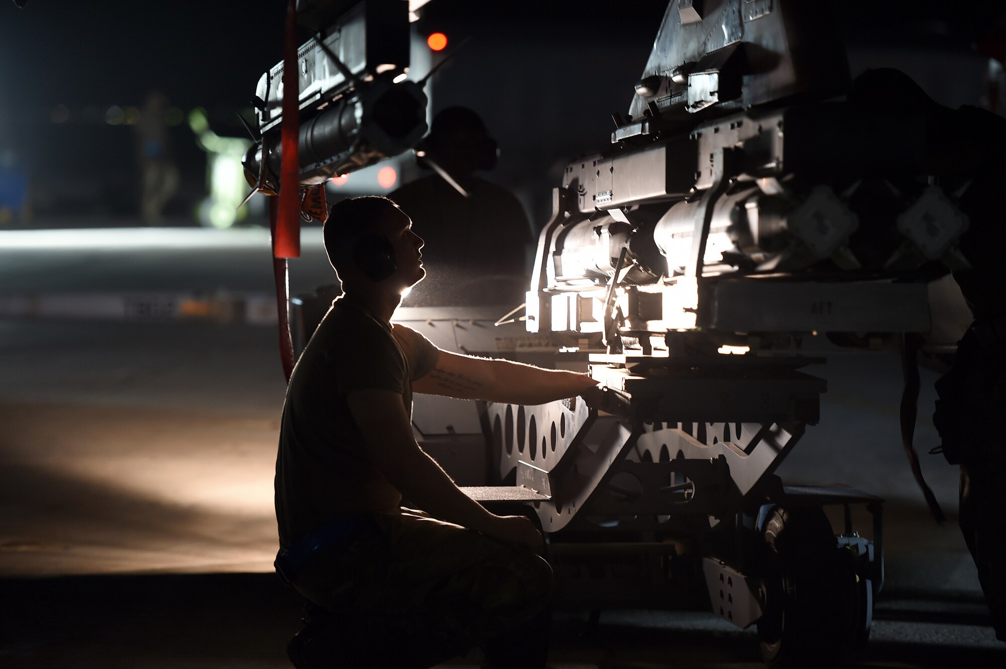 An Airmen works on the flightline at night