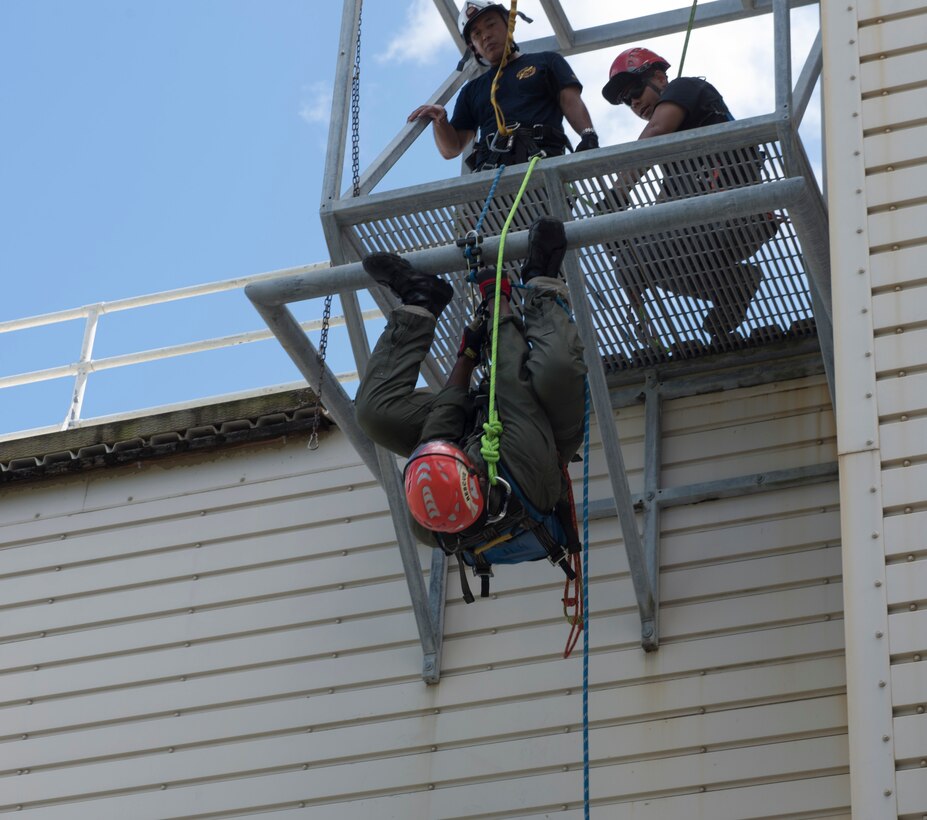 U.S. Air Force Senior Airman Jonathan Hayden, 18th Civil Engineer Squadron firefighter, hangs upside down as part of rappelling training Sept. 14, 2018, at Kadena Air Base, Japan. Safety when training is of utmost importance. Each participant was checked, re-checked and cleared by an instructor before rappelling down the building.