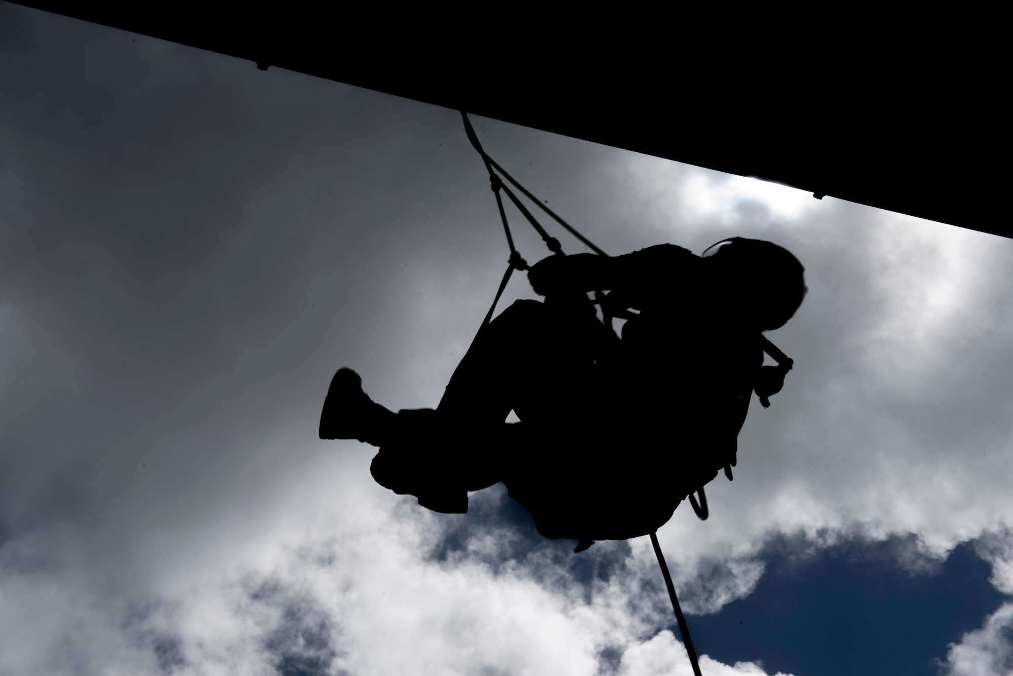 A firefighter trainee hangs from a line during rappelling training Sept. 14, 2018, at Kadena Air Base, Japan. The training aimed to instill a sense of trust in each member for their fellow firefighters, their equipment and their own abilities.