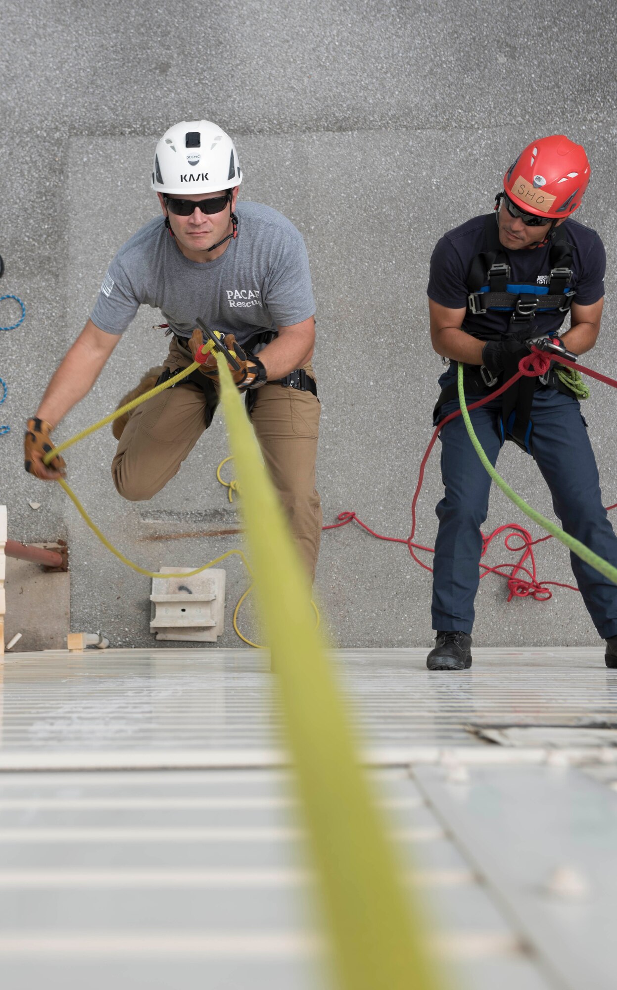 U.S. Air Force Staff Sgt. William Campbell, 18th Civil Engineer Squadron fire emergency services contingency instructor, left, adjusts his position while rappelling during a training session Sept. 14, 2018, at Kadena Air Base, Japan. Firefighters from Kadena AB, Marine Corps Air Station Futenma, Naval Base White Beach, Camp Kinser and Torii Station came together to train on rappelling techniques.